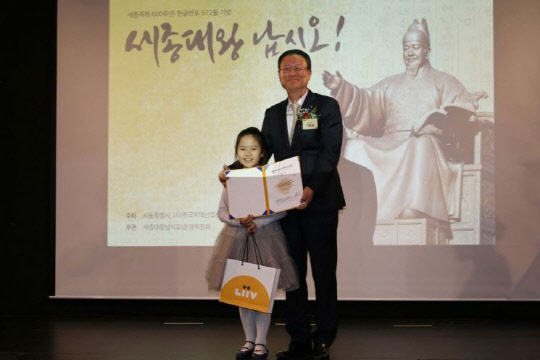 세계어린이한글손글씨대회 특선상을 시상한 신홍섭 KB저축은행 대표(사진 오른쪽)와 수상자인 이서현 학생이 기념 촬영을 하고 있다. KB저축은행 제공